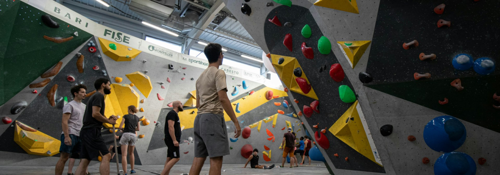 An indoor bouldering gym, with a lot of people.